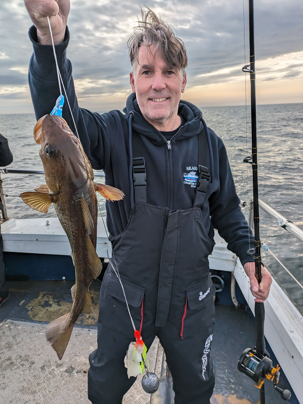 A happy passenger showing the fish they caught